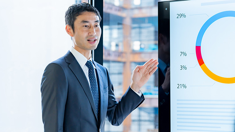 グラフをもとにプレゼンする男性