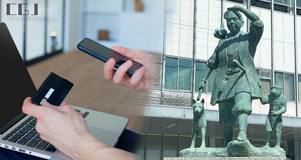 クレカ情報を入力する男性の手元と岡山駅の桃太郎像