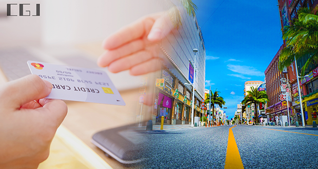 クレジットカードを手渡す手元と沖縄の国際通りの風景